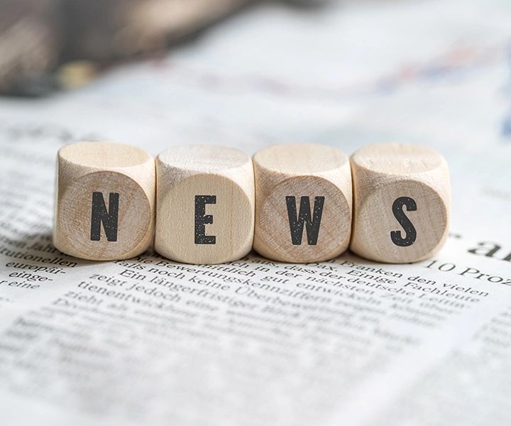 Klossar med ordet ”NEWS” som ligger på en tidning.
